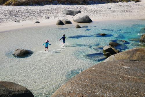 looking down on two children playing in clear blue water near beach