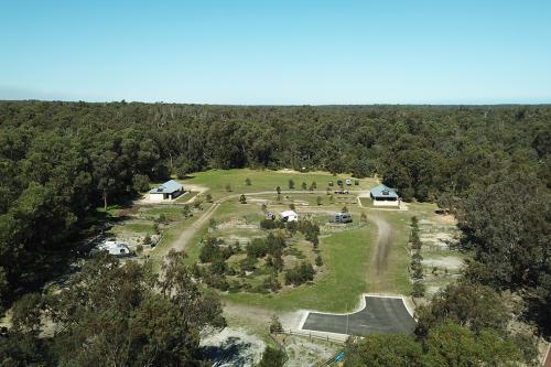 elevated view of campground and buildings in a forest clearing with blue skies