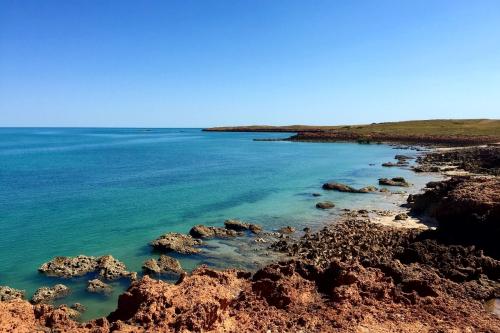 rugged coastline with turquoise waters and contrasting red rock