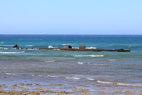 Remains of ship wreck in view close to the shore at low tide