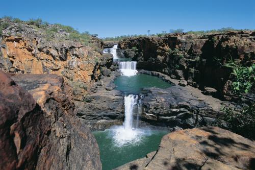 View of Mitchell Falls flowing down over three levels of rocks and pools.