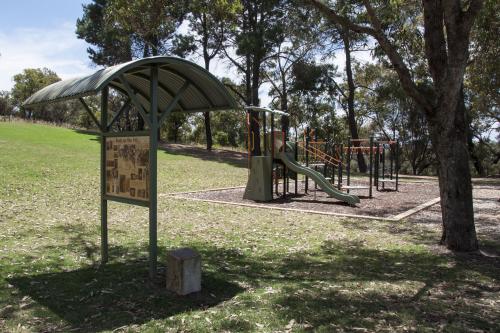 A park close to the river with playground equipment and plenty of spaces for picnics