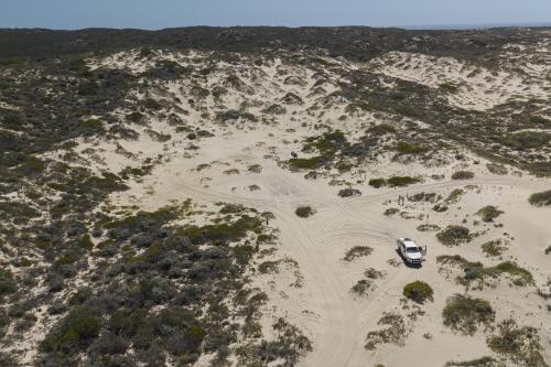 Aerial view of vehicle and tent in the sand dunes at Dampiers Landing