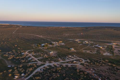 Aerial view of campground and buildings near the ocean. 