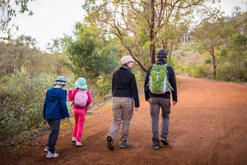 Adults and children walking on a dirt track. 