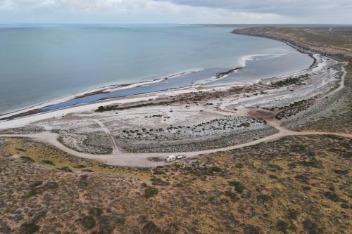 Aerial view of sandy tracks and a campsite near the beach. 