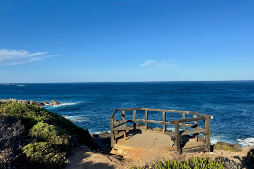 Wooden platform with railings overlooking the ocean. 