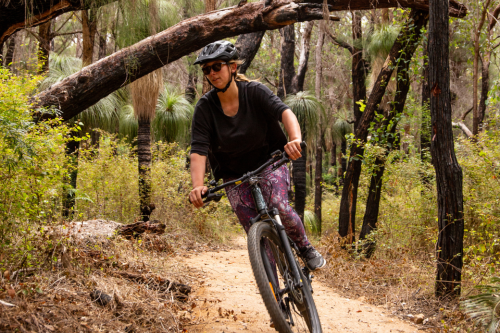Person riding mountain bike on trail.