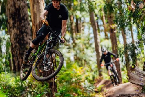 Person riding a mountian bike over a jump. 