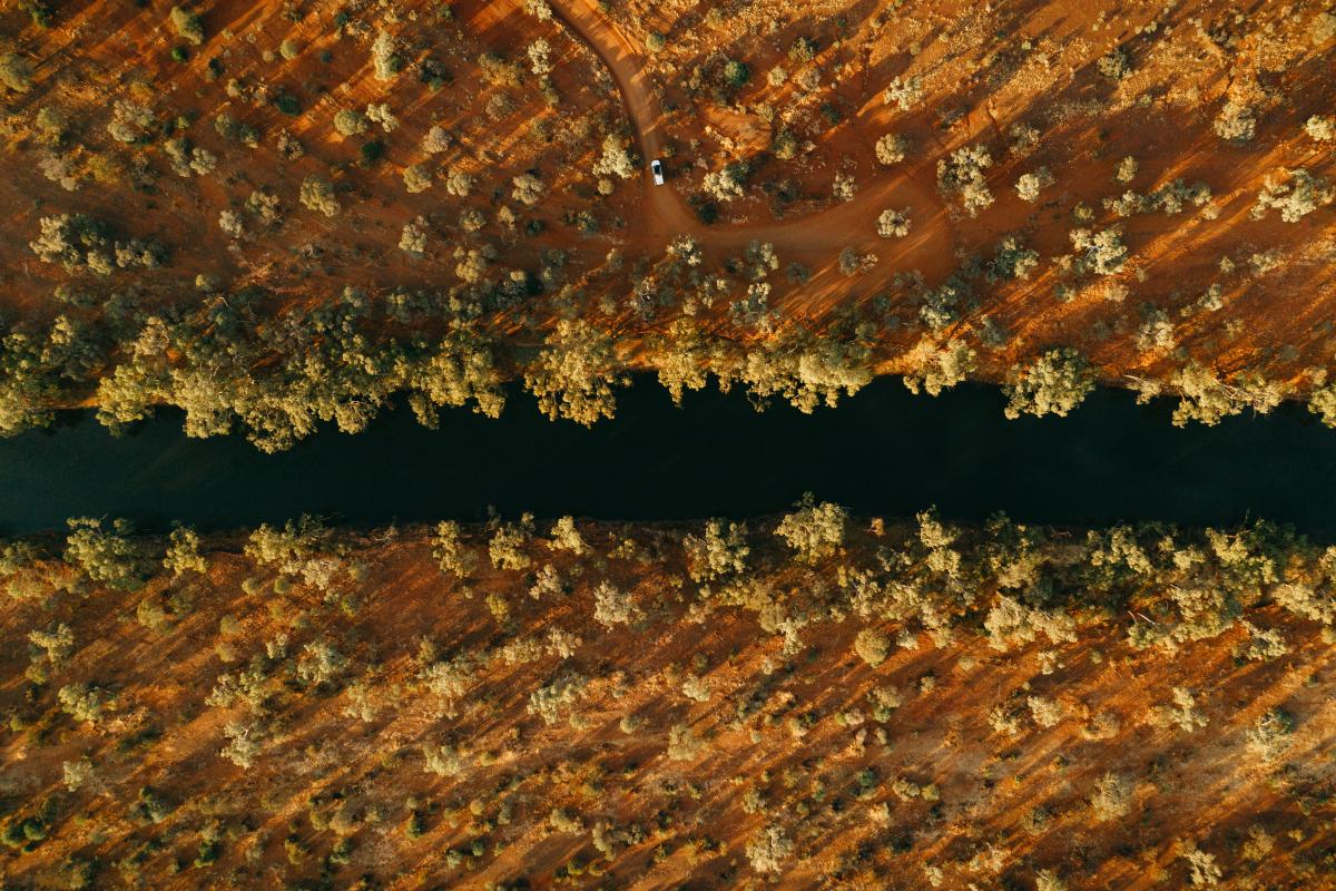 Cattle Pool Mount Augustus National Park aerial view of outback river with water outback trees and a vehicle driving on a red dirt track
