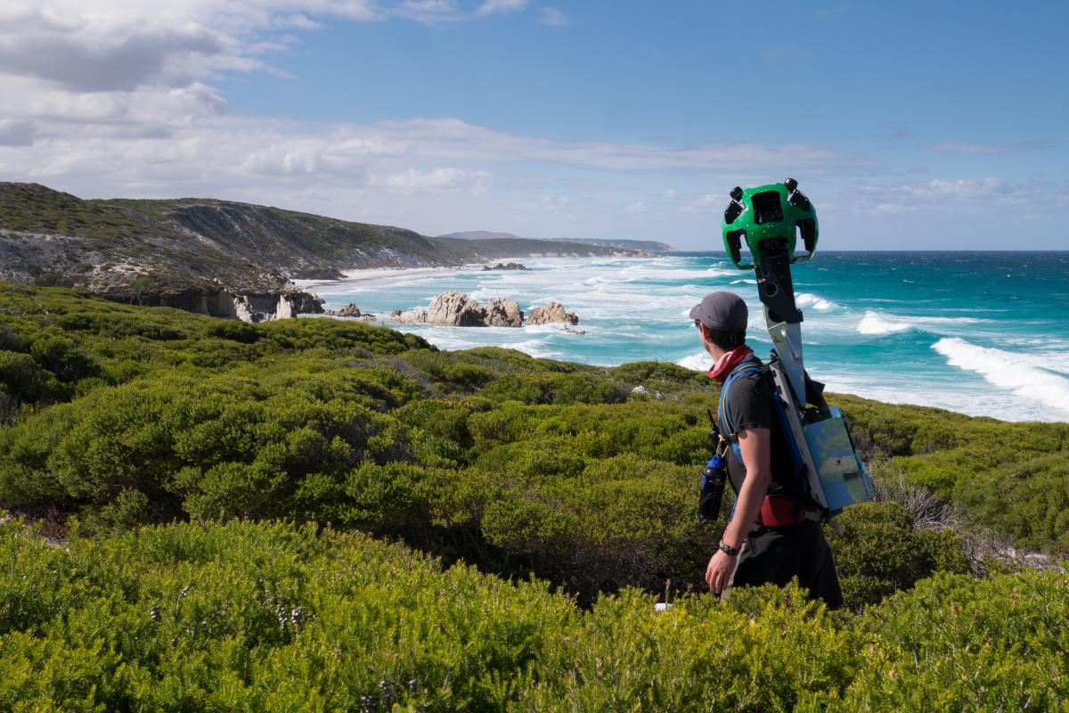The Google Trekker on the Hakea Trail man walking on path through green shrubs looking at view of coastline