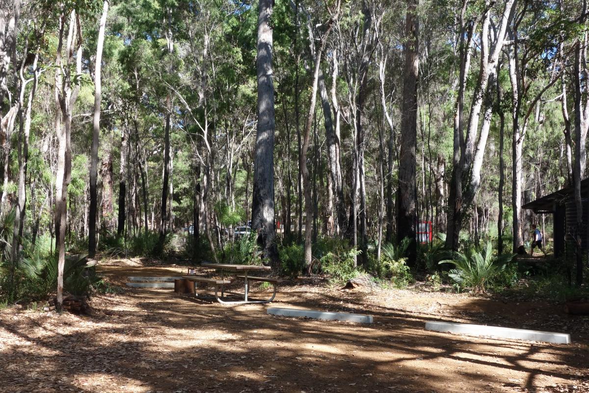 Jarrahdene Campground Leeuwin Naturaliste National Park picnic table in a clearing beneath shady trees in a forest campground