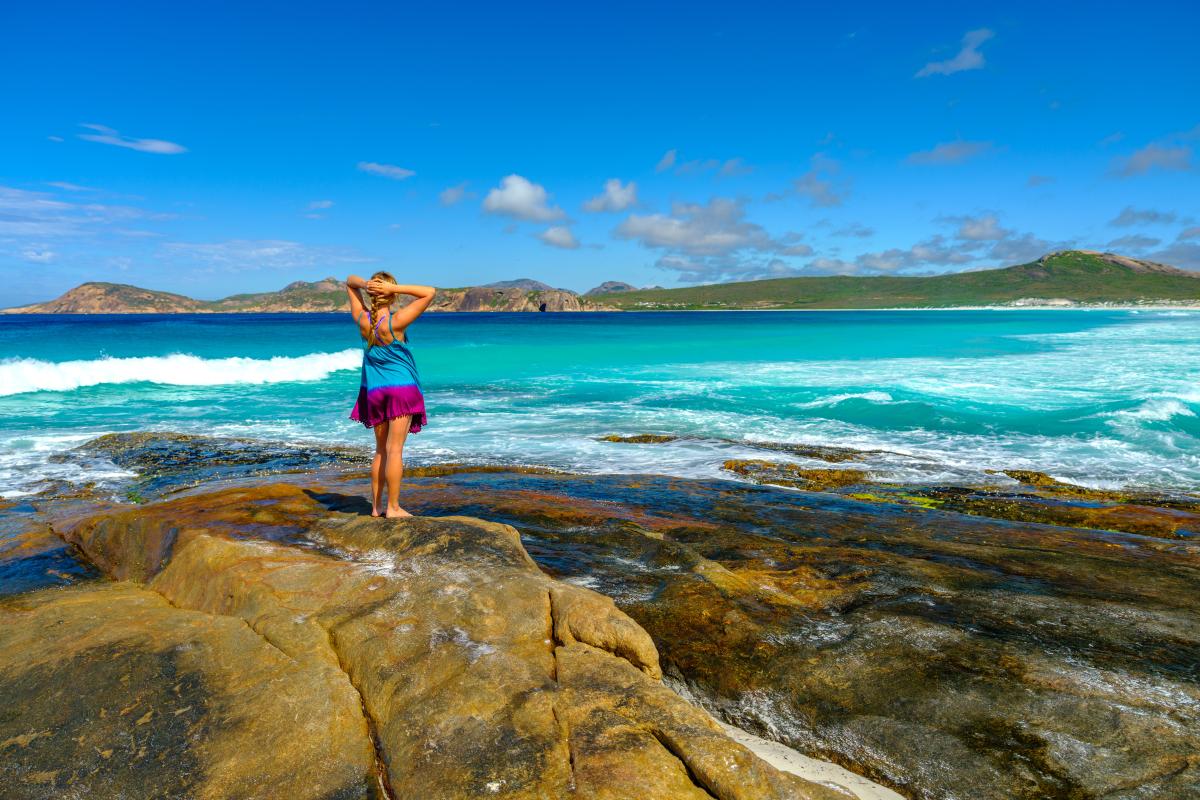 woman admiring a coastal view and turquoise blue ocean