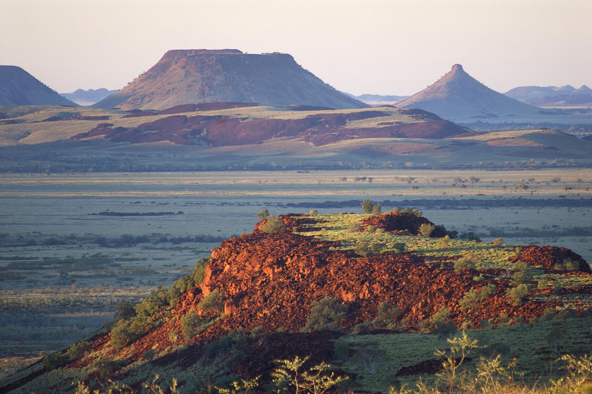 views of red dirt hills covered in low green scrub