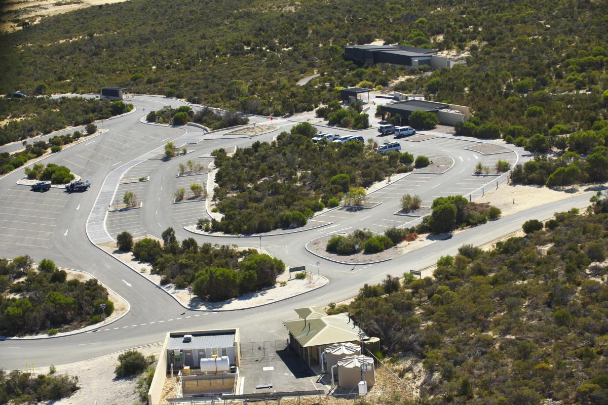 aerial view of a carpark with some buildings set in a bushland landscape