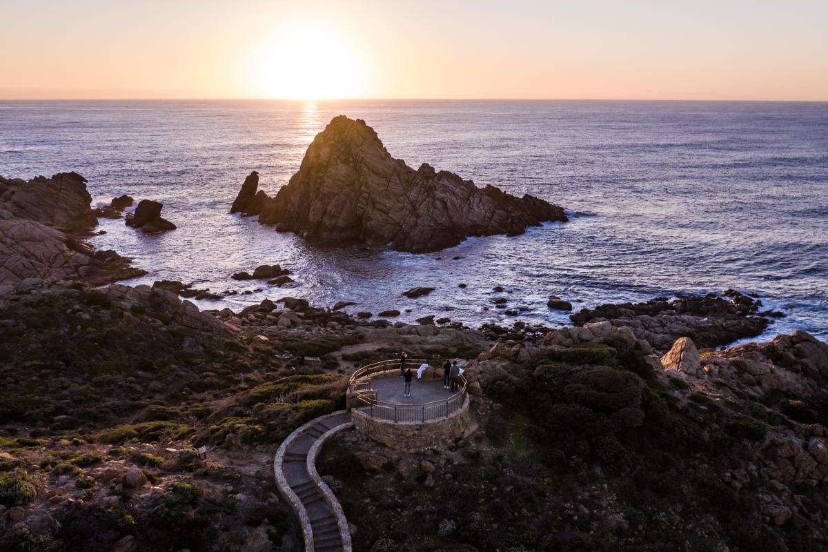 Sunset at Sugarloaf Rock People standing on lookout watching the sunset over the ocean near a granite island