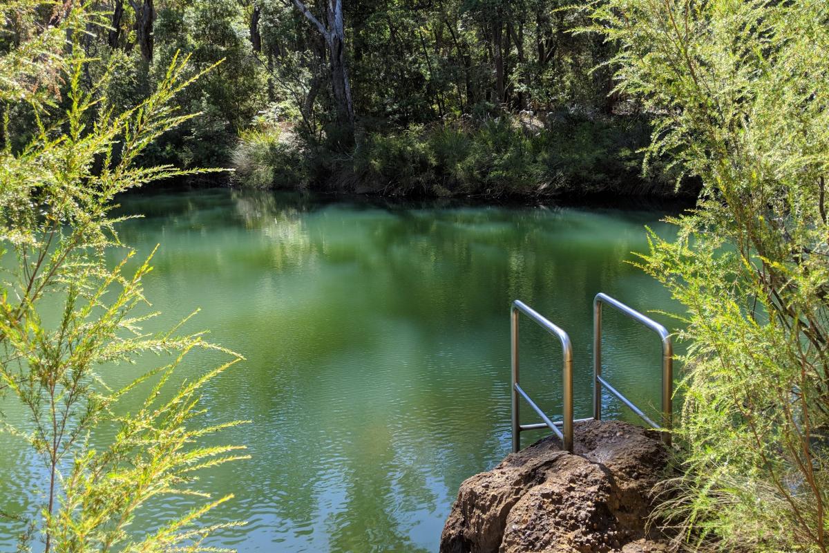 Natural river pool with a ladder down to the water