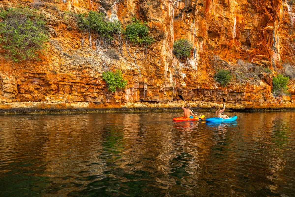 Couple paddling on kayaks in gorge