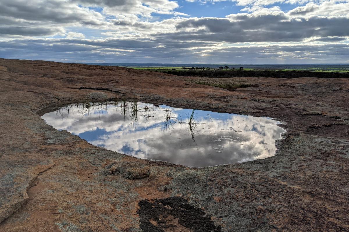 Reflections in the sky in a rock pool on a granite outcrop