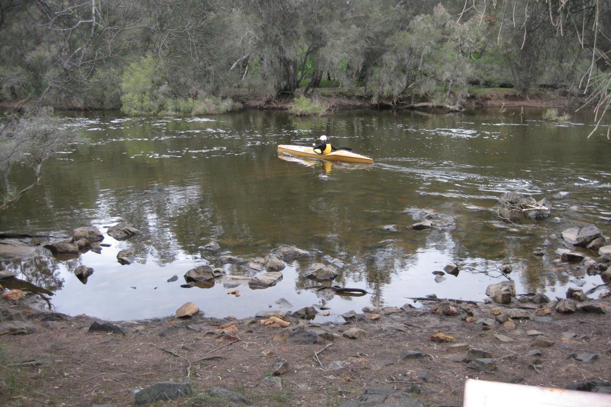 Canoeing in Walyunga National Park a person paddling in a yellow canoe on the avon river