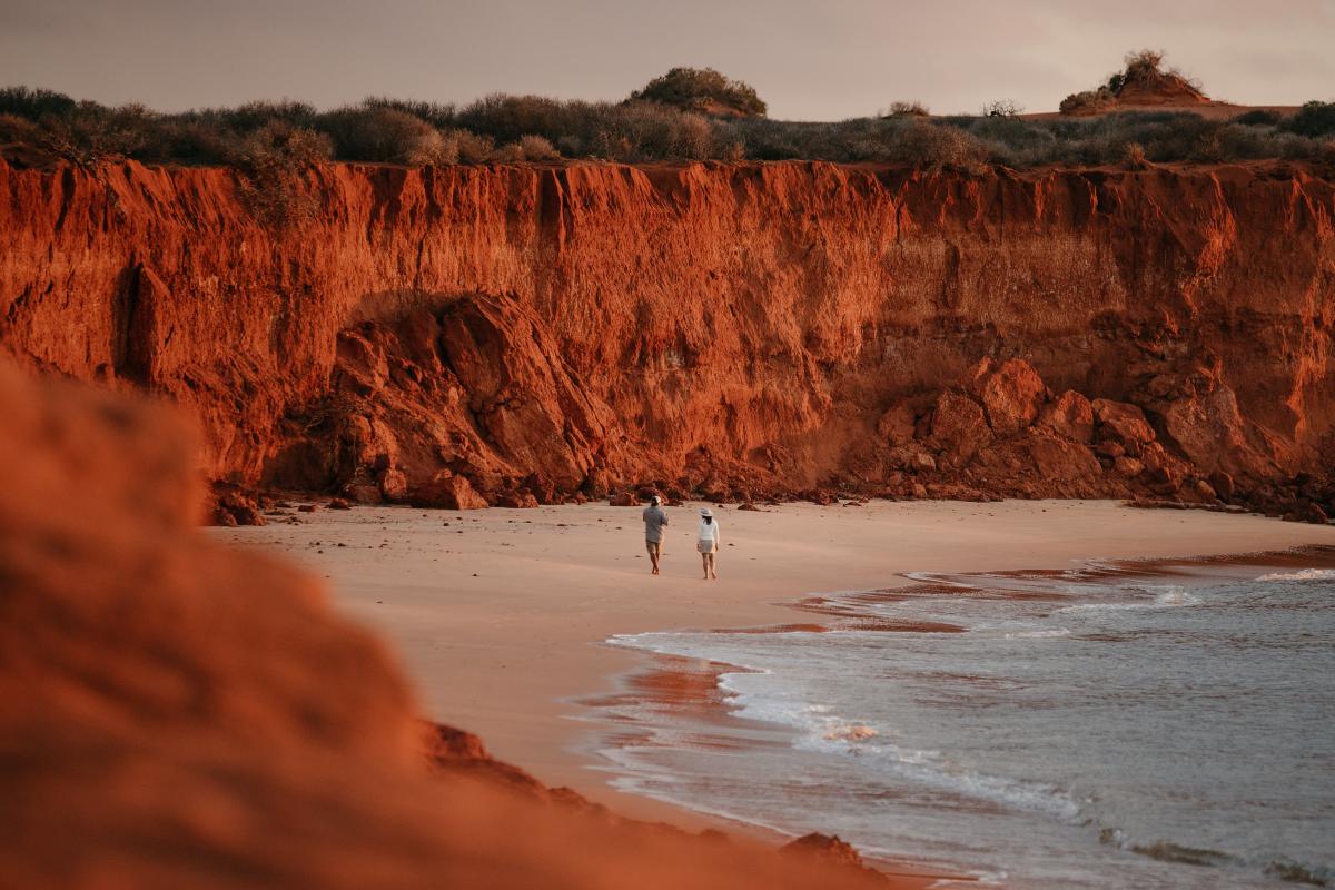 Cape Peron, Francois Peron National Park Visitors on beach with surrounding red rock wall towering above