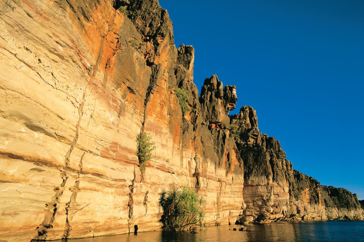 reflections of limestone cliffs onto the river surface with clear blue sky in the background