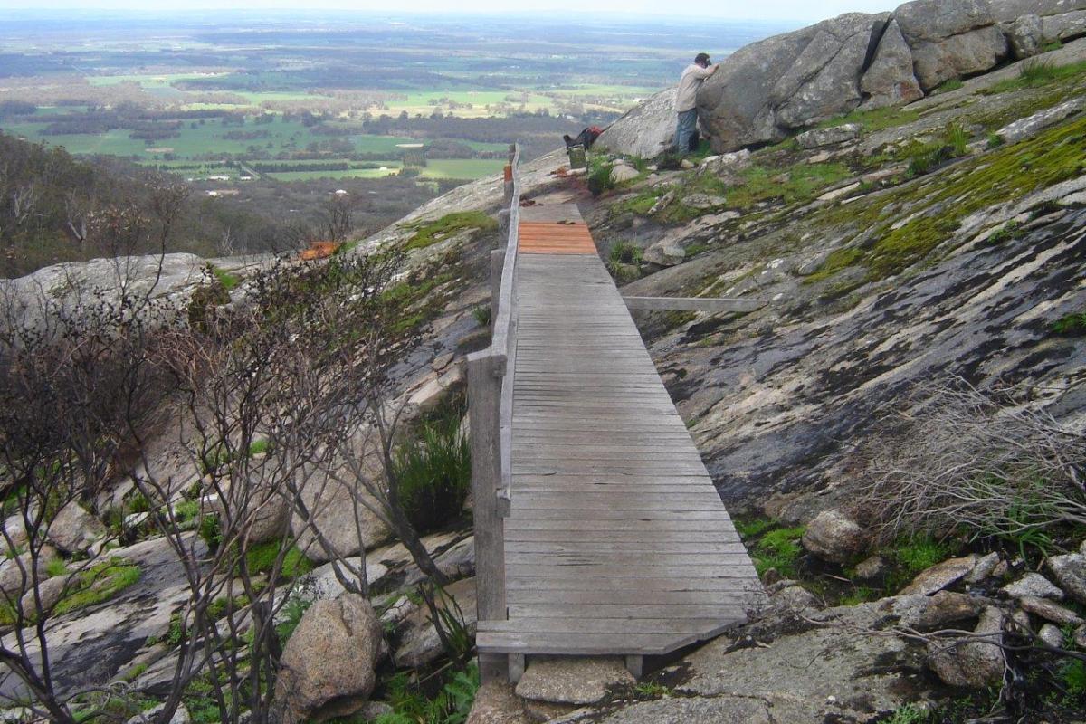 Devils Slide trail in Porongorup National Park wooden boardwalk on the side of a massive granite hill