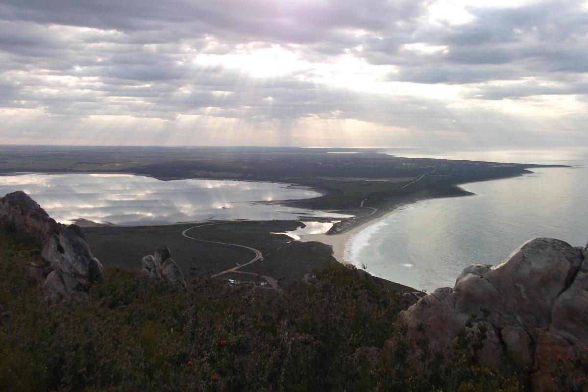 aerial view of the sun glinting through clouds down to coastal geography at East Mount Barren