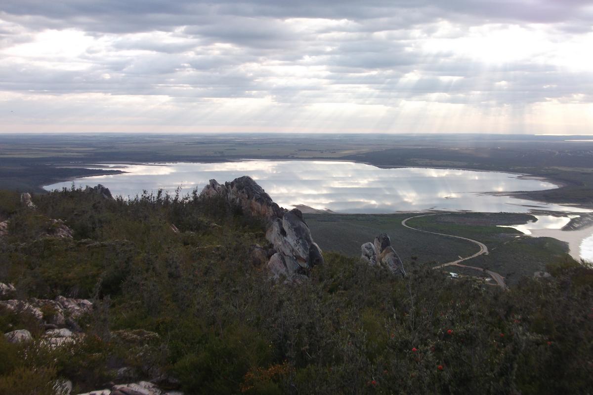 aerial view of the sun glinting through clouds down to scenic coastal geography at East Mount Barren