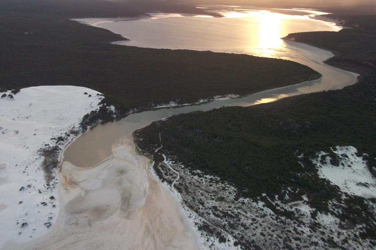 Aerial view of Fitzgerald Inlet with the sun glistening on the water at sunset