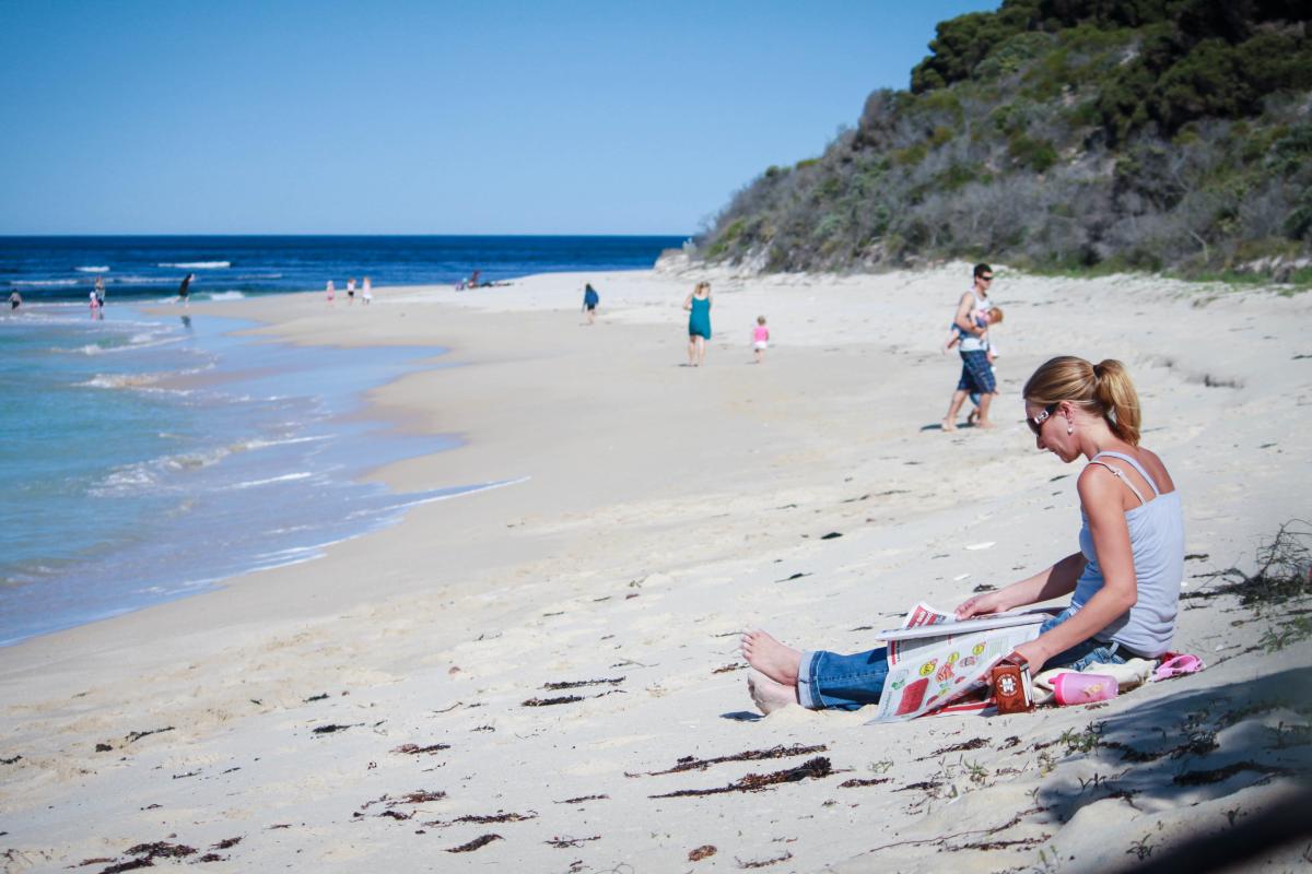 Visitors sitting on the beach.