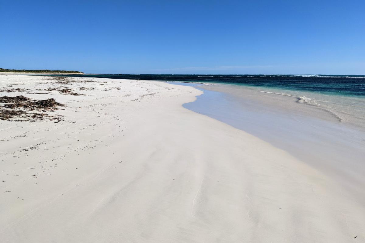 White sand and blue water on a windy afternoon at Hangover Bay