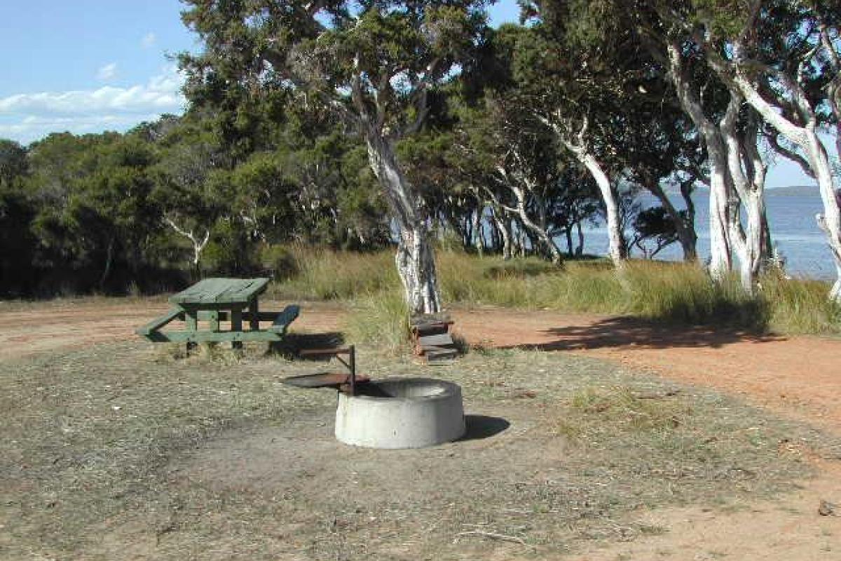 Picnic bench and fire ring next to the Irwin Inlet