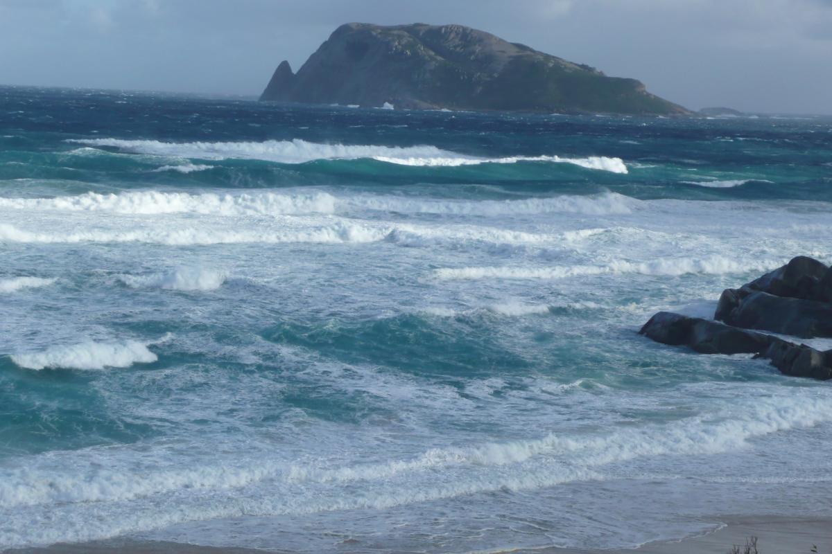 rolling surf with an island in the background