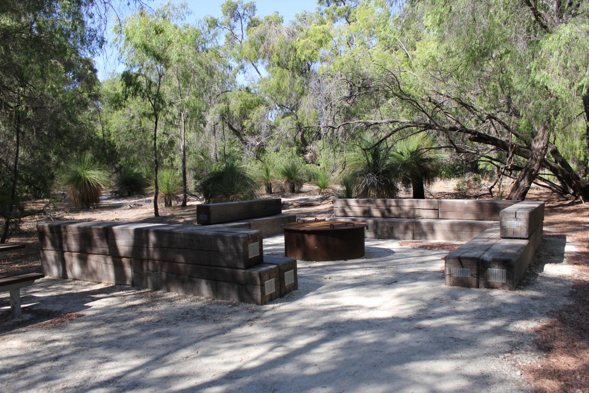 picnic area and fire pit in the shared area with trees behind