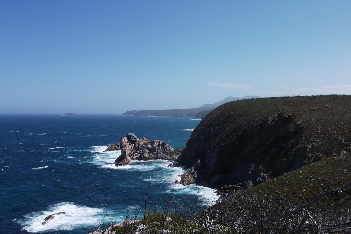 looking down at the jagged rocks and crashing ocean waves at Quoin Head