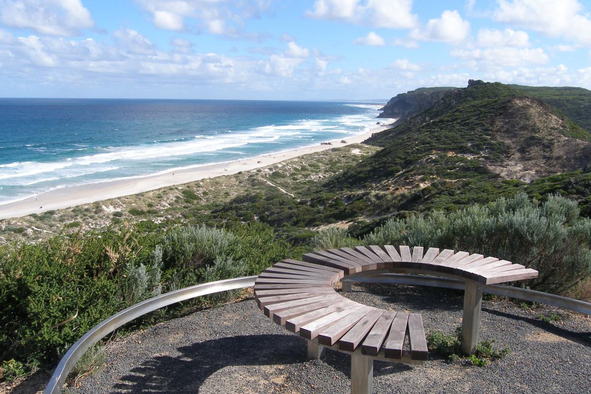 seating that overlooks the coastal heath and white sandy beach and blue ocean