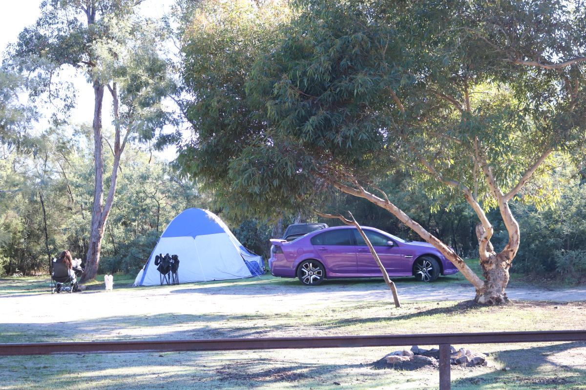 campers set up with a tent and fold up chairs