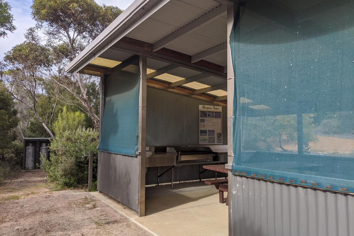 Undercover picnic area with benches, sink and bbq facilities at Stokes Inlet