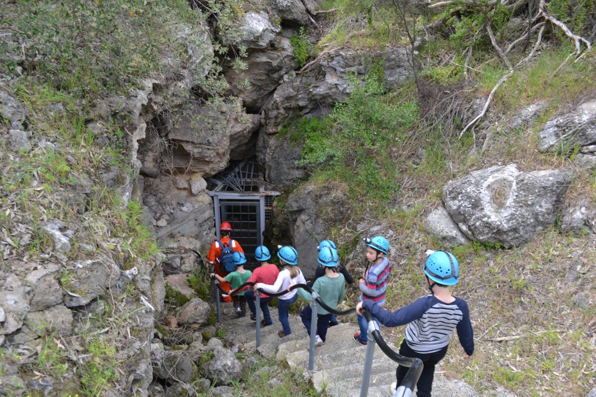 Young visitors walking down to explore the cave