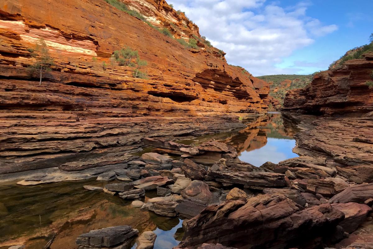 sunlight glinting over banded layers of sandstone rock in Kalbarri National Park