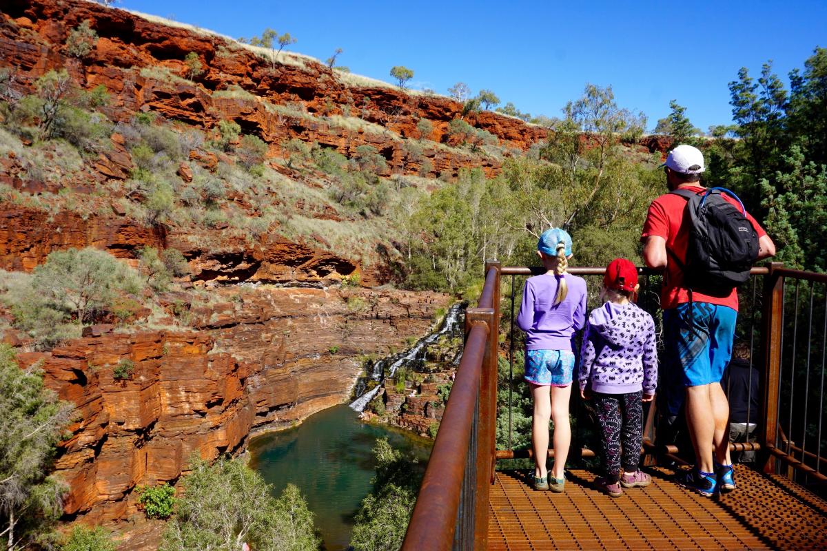 people viewing the water cascading over the rocky formation at Dales Gorge