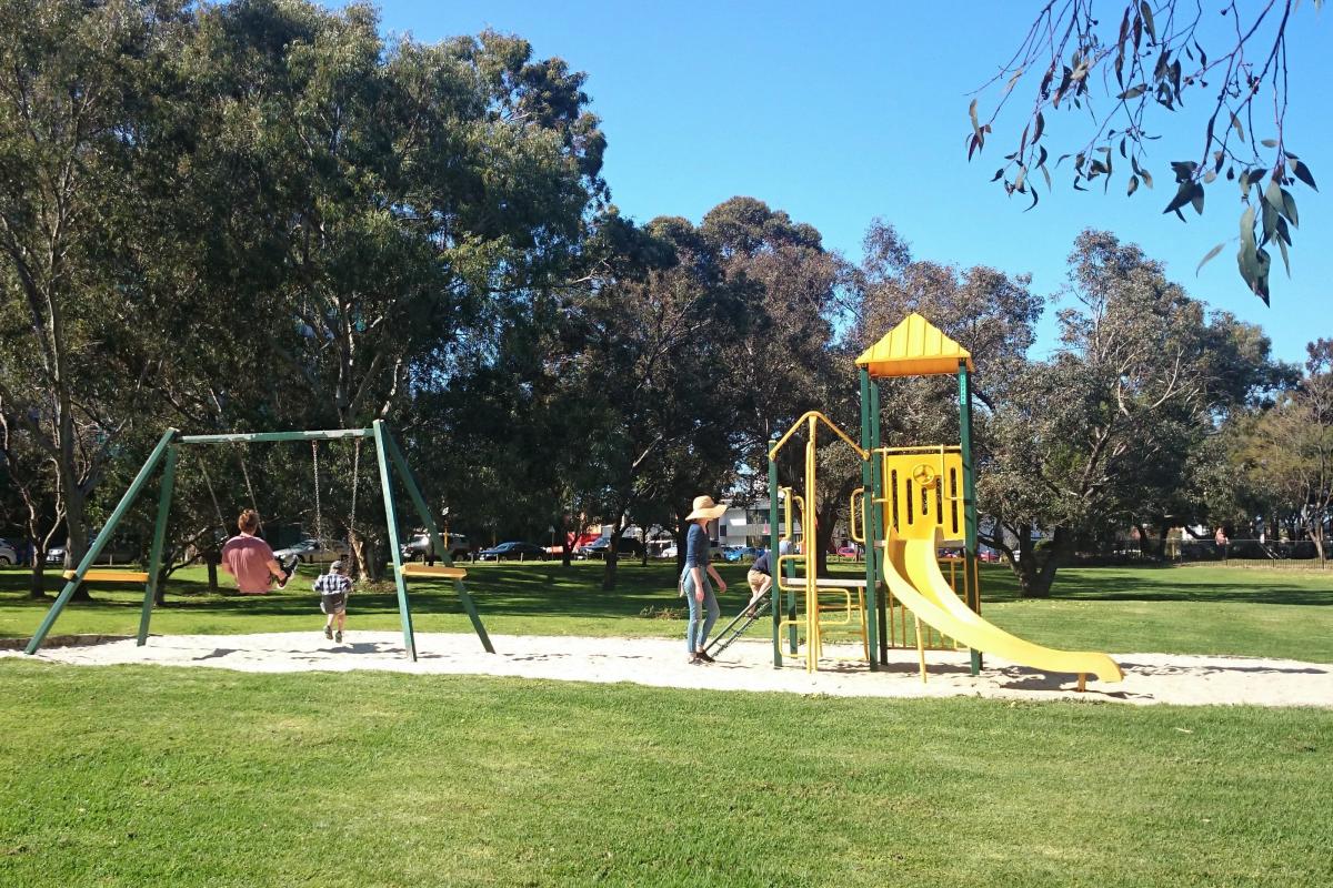 A family enjoying swings and slides at the playground at the northern end of the park.