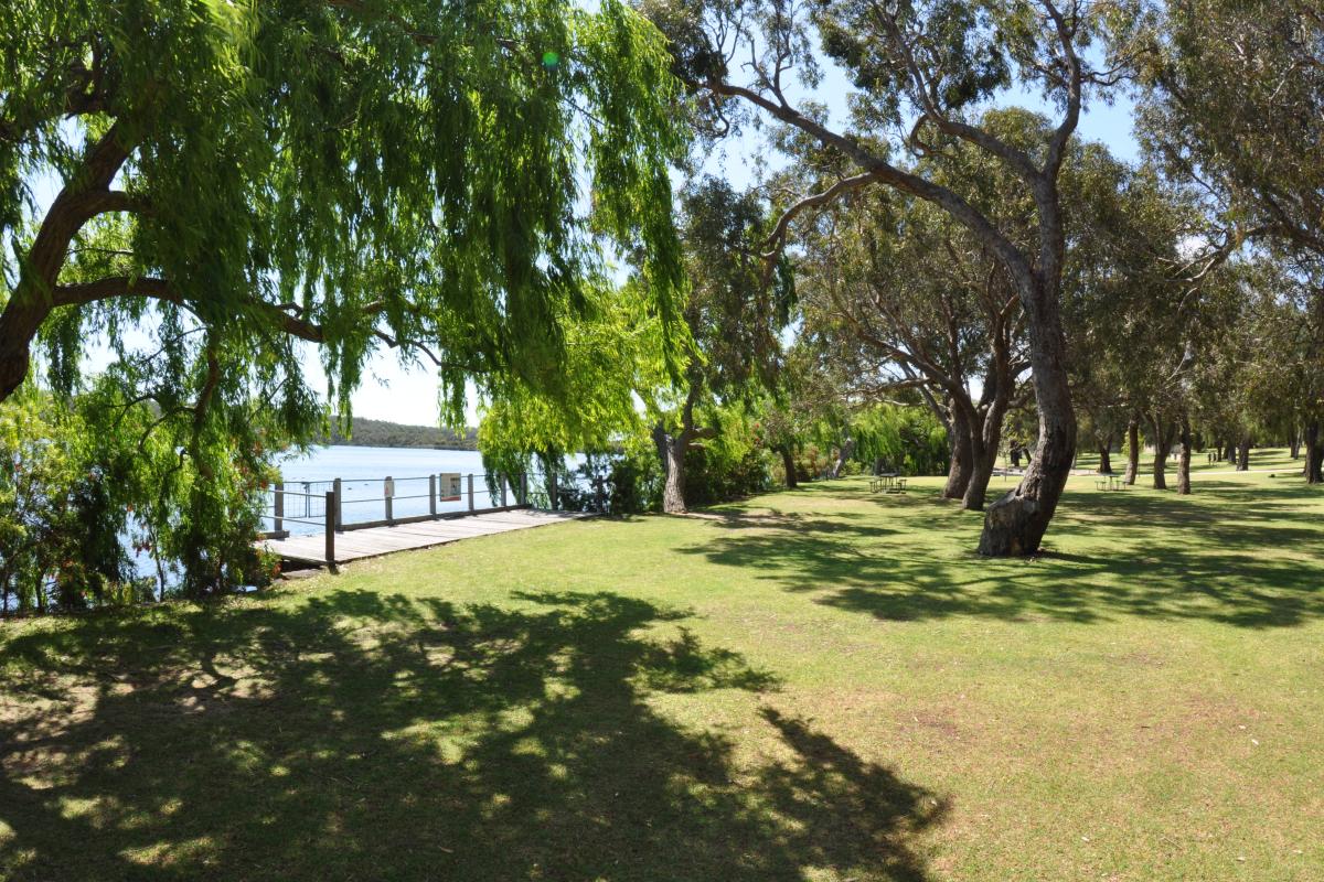 green lawns and shade trees near a viewing deck overlooking the lake