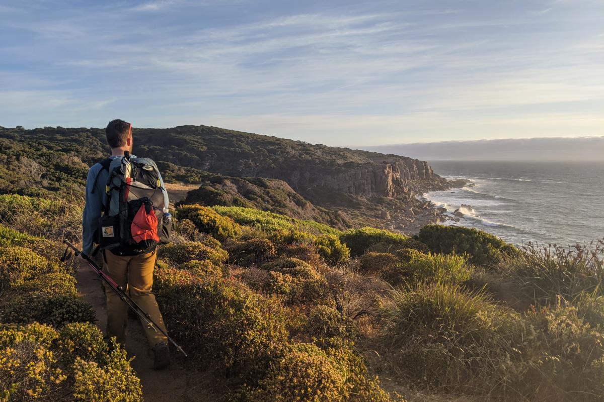A person hiking the Cape to Cape Track late in the day near Wilyabrup Cliffs in Leeuwin-Naturaliste Natoinal Park