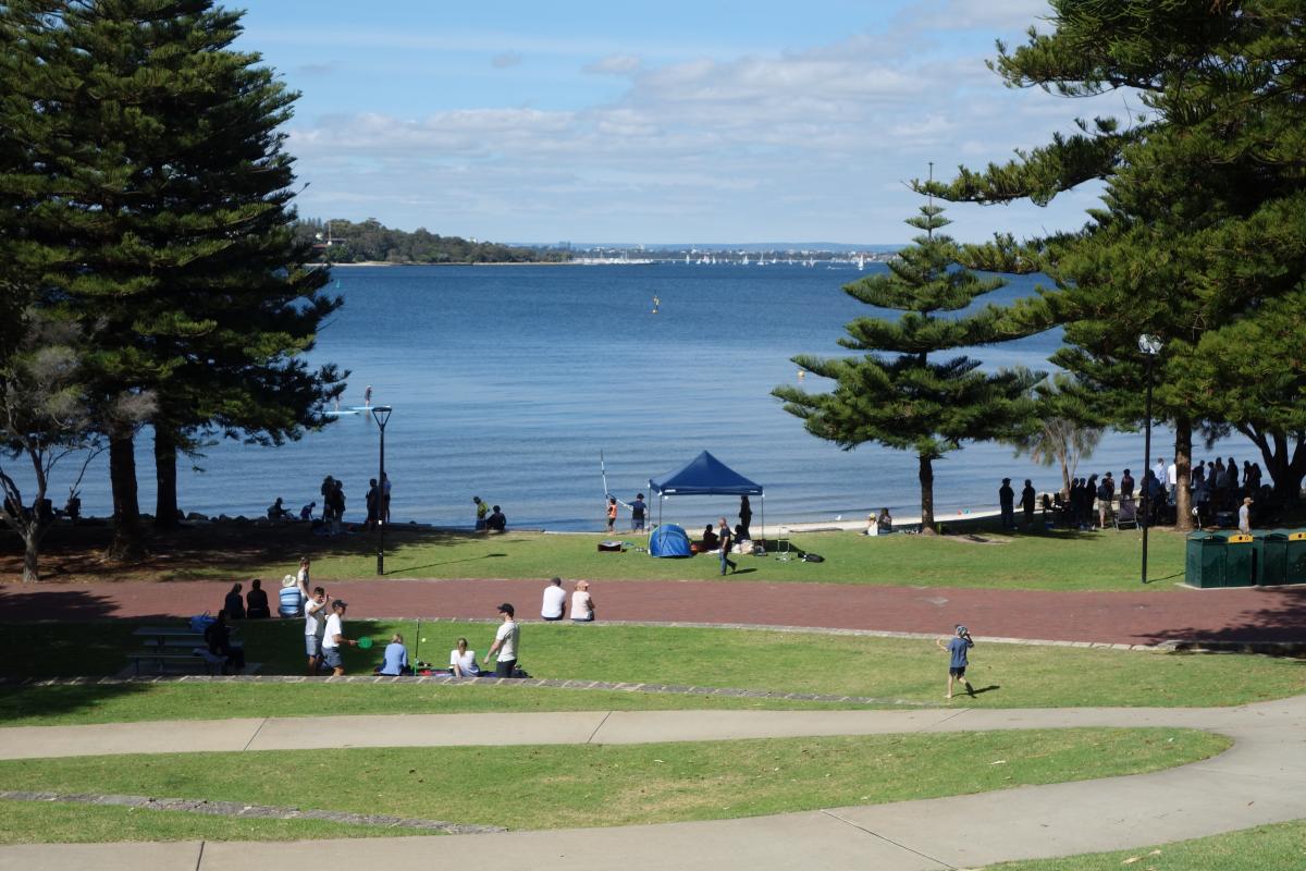 People enjoying picnics, swimming and paddling on a calm, sunny day at Point Walter