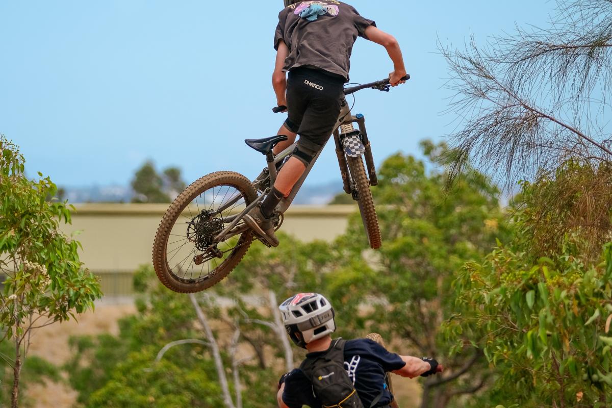 Two mountain bike riders doing aerial tricks.