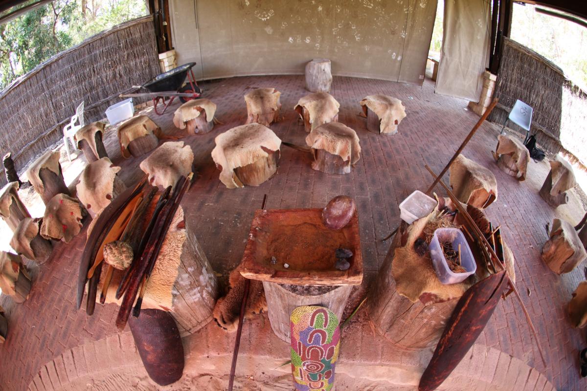 gathering area with wood block stools and kangaroo skins over them
