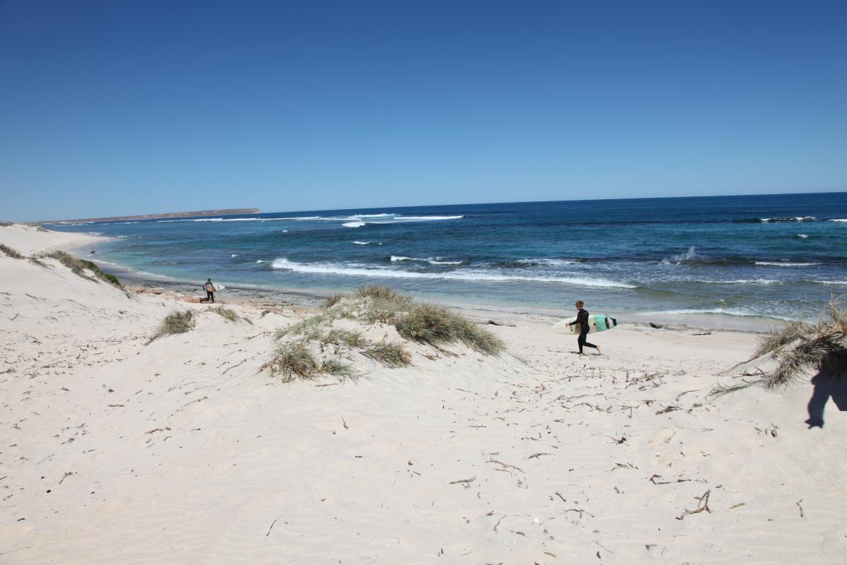 Surfers on the beach at Majuns Turtle Surf Break