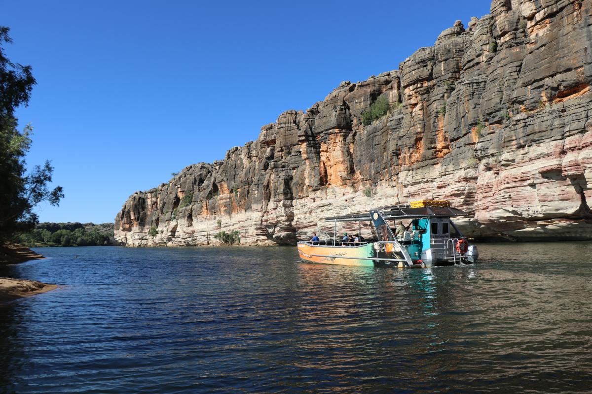 miss casey ross tour boat with banded limestone in the background and clear blue sky